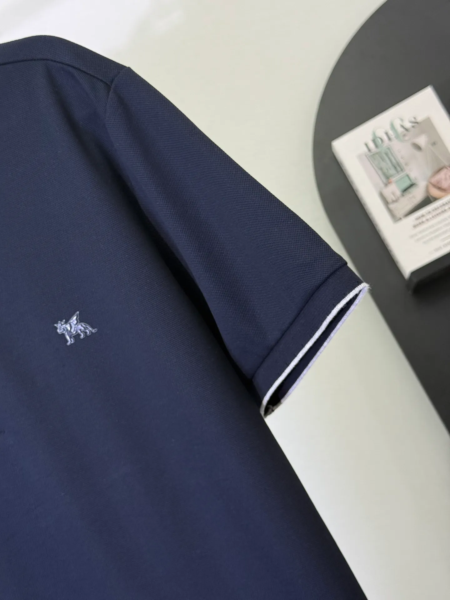 💋 Brunello Cucinelli Navy Pegasus Polo Shirt. Put the low-key luxury of Italy’s “King of Cashmere” into this calm navy blue Polo. The delicate Pegasus embroidery on the chest, with contrasting white edge details on the collar and cuffs, is low-key yet highly recognizable on the deep navy blue background. It is the first choice for players who truly understand texture. The high-count piqué cotton fabric is selected to be drape-resistant and wrinkle-resistant. The upper body has a neat and straight noble feeling. The fit is slightly loose and does not matter the body shape. It can be easily held in business commuting and light formal occasions. A navy blue Polo can guarantee your dignity and style in all occasions in four seasons. M-3XL